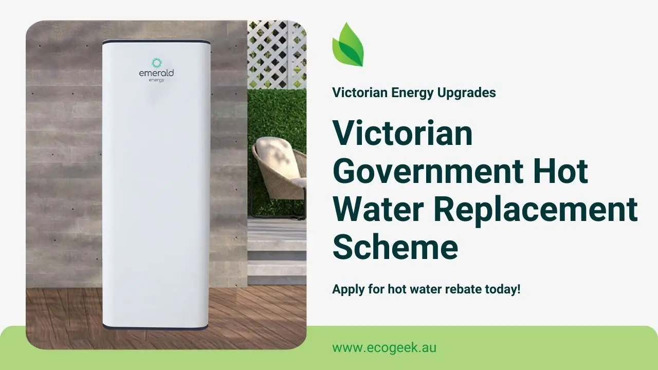 Outdoor promotional image featuring a modern hot water system labeled “emerald energy” on a timber deck, with a chair and decorative wall in the background. Text highlights the Victorian Government’s Hot Water Replacement Scheme and rebate offer, with a link to ecogeek.au..